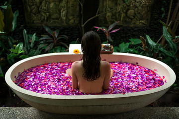 Beauty young Woman relaxing in outdoor bath with tropical flowers.Spa,organic and skin care concept. © tatyanasuyarova