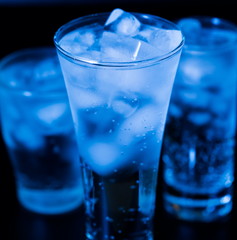 Drink. Water glass and ice, dark background