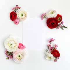 Obraz na płótnie Canvas Frame with pink and red ranunculus, on white background. Flat lay, top view