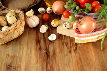 Ingredients for cooking fried eggs with vegetables on wooden background