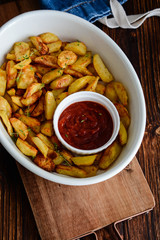 Baked fried potatoes with garlic and red sauce.