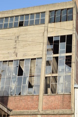 Broken windows on old factory building © mirzamuradbasic