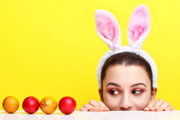 Happy young woman wearing bunny ears and having Easter Eggs