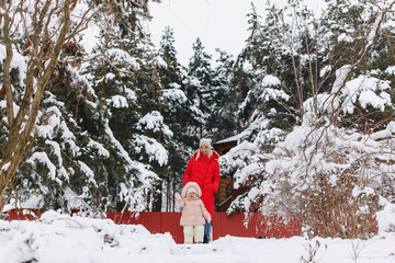 mother with baby walking picturesque country cottage in