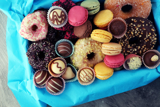Different types of macaroons, donuts and pralines in a box