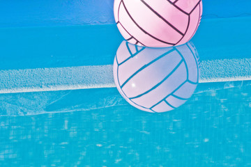 Pelota rosa en piscina azul