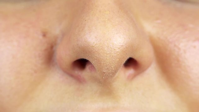 A woman smells with her nose - closeup