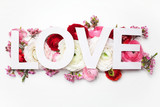 Creative layout with colorful flowers, leaves and Word LOVE. Love concept.Flat lay.
