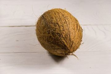 Whole coconut on white wooden table