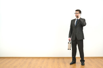 The man with a case phones on the white wall background