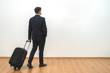 The man with a bag standing on the white wall background