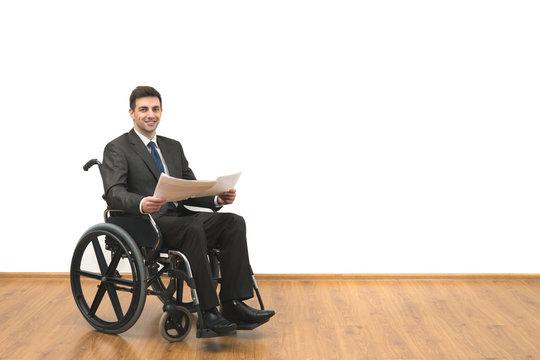 The smile man in the wheelchair holding papers on the white wall background