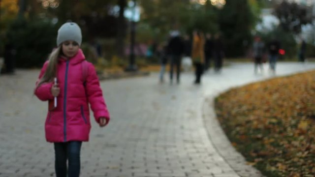 Adorable, frightened schoolgirl, on walk on street, in city, alone. Child lost.