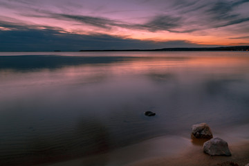 Sunset at the beach with rocks in the foreground