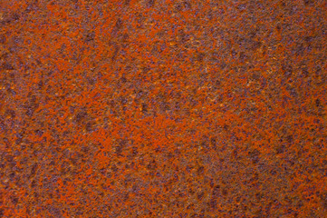 Rusty yellow-red textured metal surface. The texture of the metal sheet is prone to oxidation and corrosion. Grunge background