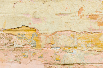 Close-up Textured background of multi-layer flaking paint on the wall. Mixing different colors of paints in the cleaved layers on the surface. Grunge texture with a deep pattern