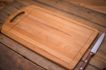 Wooden cutting board with knife. Place for text. Recipe design horizontal. Top view