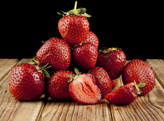 fresh strawberry fruit on a wooden table isolated on a black background