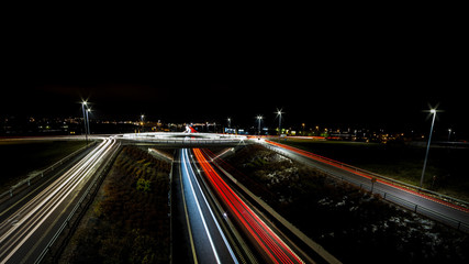 Fototapeta na wymiar light trails for cars passing a roundabout and roadside sides
