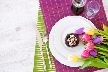Beautiful table setting with crockery and flowers for Easter celebration