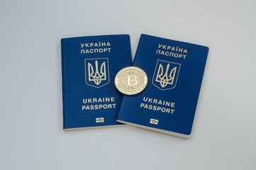 Ukrainian foreign passports and bitcoin coin. Ukraine and cryptocurrency concept. Isolated on white background