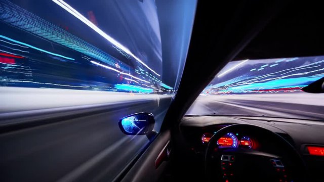 Timelapse video View from Side of Car moving in a winter night city, Blured road with lights with car on high speed. Concept rapid rhythm of a modern city.