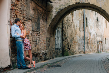 Fototapeta na wymiar Young happy couple hugging on the street. Smiling man and woman having fun in the city.