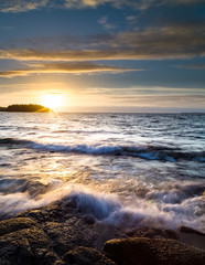 powerful waves against rocks at sunset