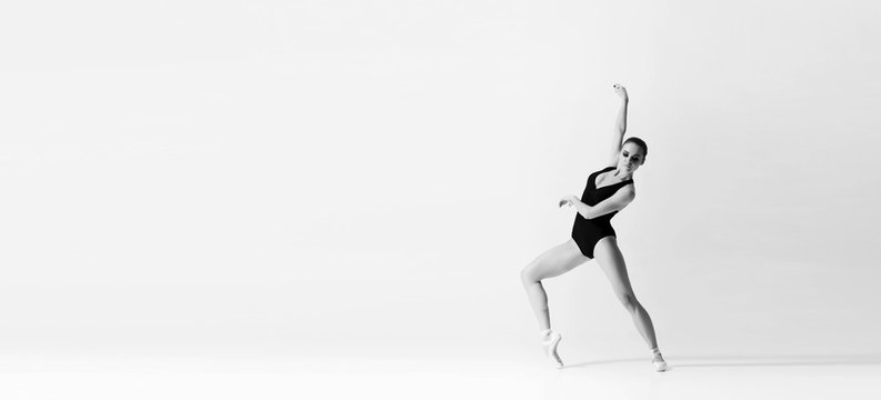 Graceful ballerina dancing in art performance. Young and beautiful ballet dancer in black and white.