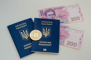 Ukrainian foreign passports and money and bitcoin coin. Ukraine and cryptocurrency concept. Isolated on white background.