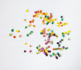 Colorful lollipops, candy canes and sweet candies mix on wooden background