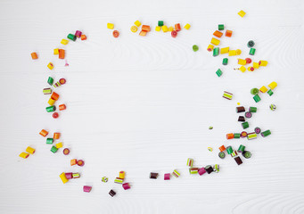 Colorful lollipops, candy canes and sweet candies mix on wooden background