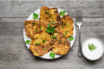 Potato Pancake with sour cream and fork on rustic wooden table
