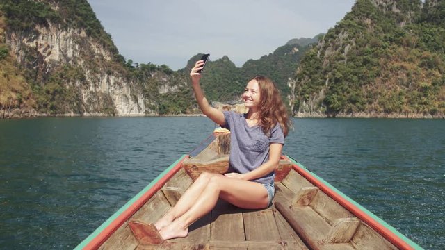 Happy woman traveler relaxing on boat and taking selfie. Andaman sea, Surin island, Phangnga,Travel in Thailand, Beautiful destination Asia, Summer holiday outdoors vacation trip