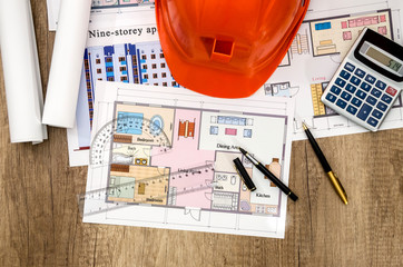 construction drawing with a calculator and a helmet on the table