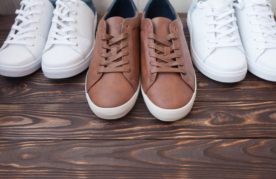 Various pairs of colorful sneakers laid on the wooden floor background