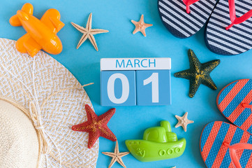 March 1st. Image of march 1 calendar with summer beach accessories and traveler outfit on background. Spring like Summer vacation concept