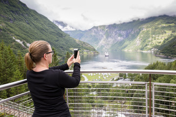 Fototapeta na wymiar Taking a picture in Geirangerfjorden.