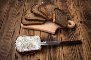 Fototapeta na wymiar corn bread cut into pieces and butter on a wooden background