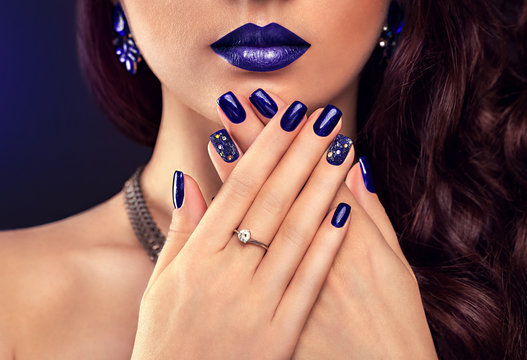 Beautiful woman with perfect make-up and blue manicure wearing jewellery