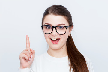 Surprised astonished lady has shocked expression, points with fore finger at copy space on ...