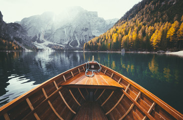 Wooden rowing boat on a lake in the Dolomites in fall