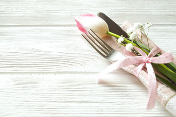 Easter laying table appointments, table setting options. Silverware, tableware items with festive decoration. Fork, knife and flowers. Happy easter holiday.