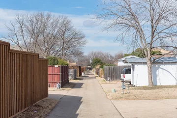 Fotobehang Smal steegje Small back alley at  suburban neighborhood in North Dallas, Texas, USA. Narrow concrete pathway leading to horizontal  © trongnguyen