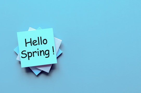 hello spring text sign on empty blue background with space for text. stylish flat lay