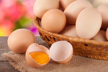 eggs in a wicker basket on a wooden board with blurred garden background