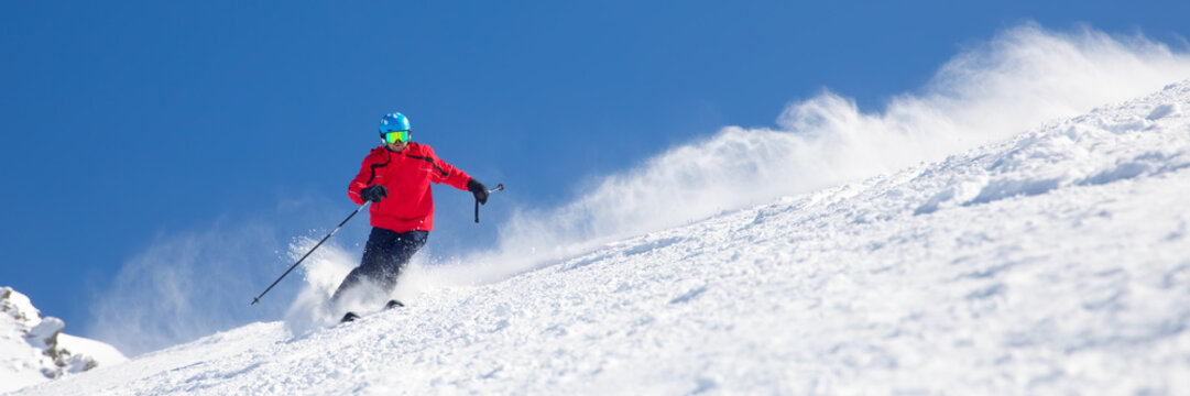 Man skiing on the prepared slope with fresh new powder snow.