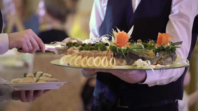 Waiter takes piece of sterlet fish