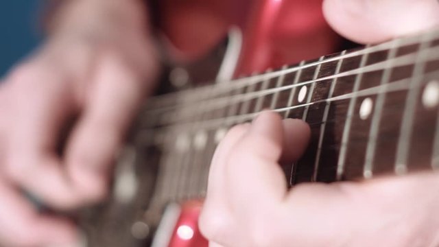 Close up of electrig guitar player hand performing a solo
