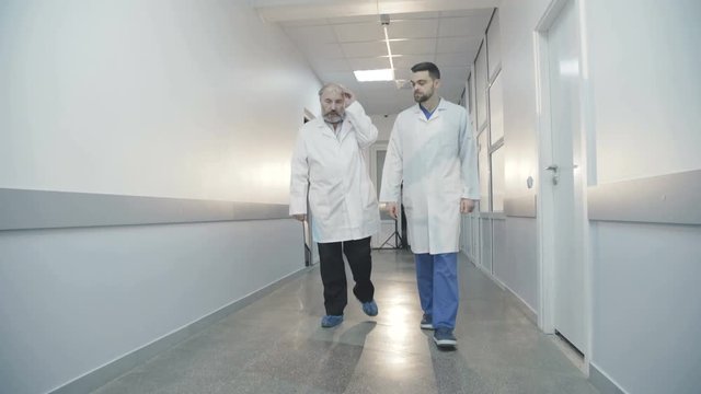 Co-doctors walking in hospital and advising 4K
